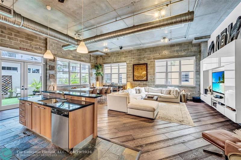 a living room with stainless steel appliances granite countertop a stove and a refrigerator