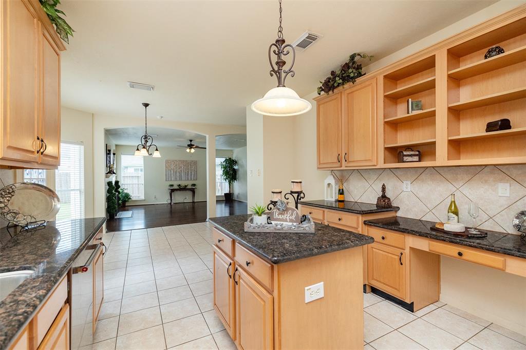 a kitchen with granite countertop a sink stove and cabinets