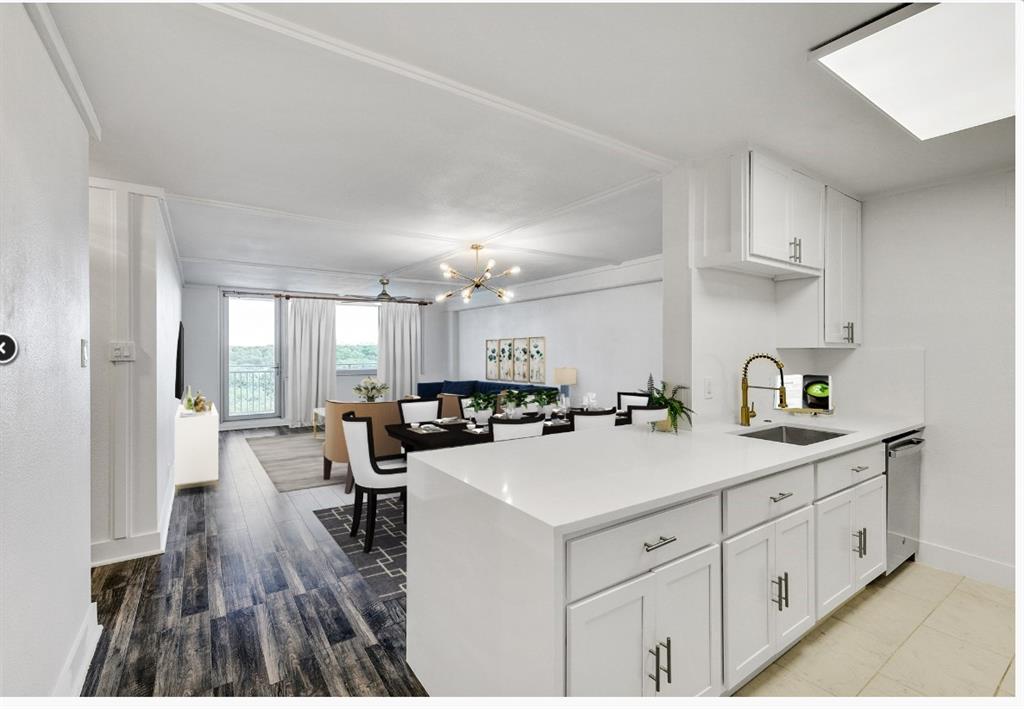 a kitchen with a sink a stove cabinets and wooden floor