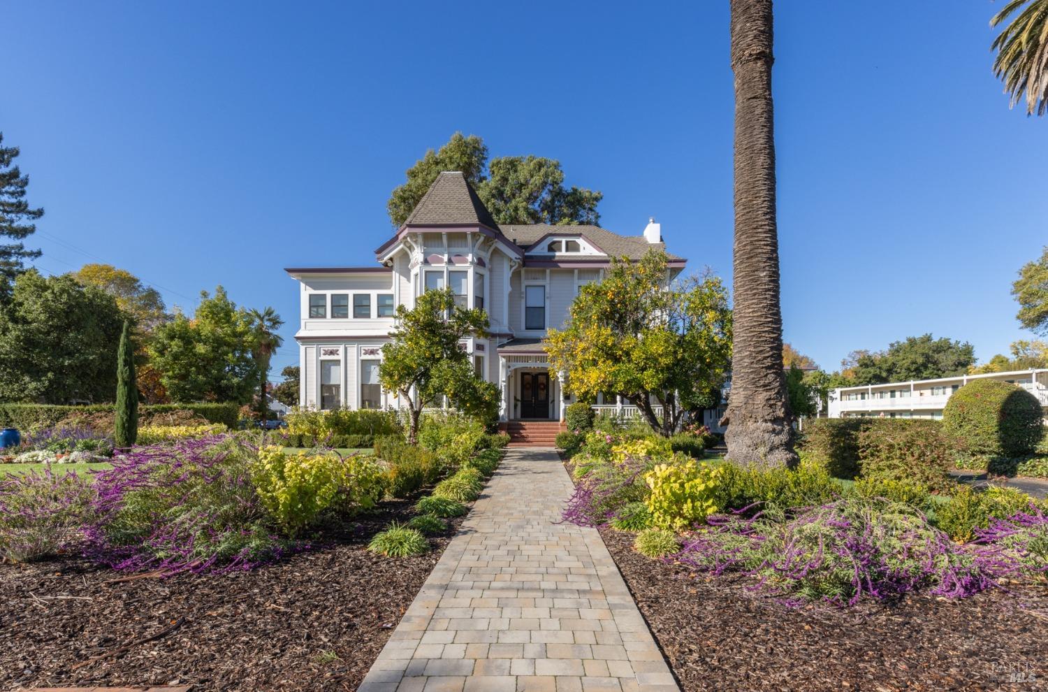 a front view of a house with a yard and potted plants