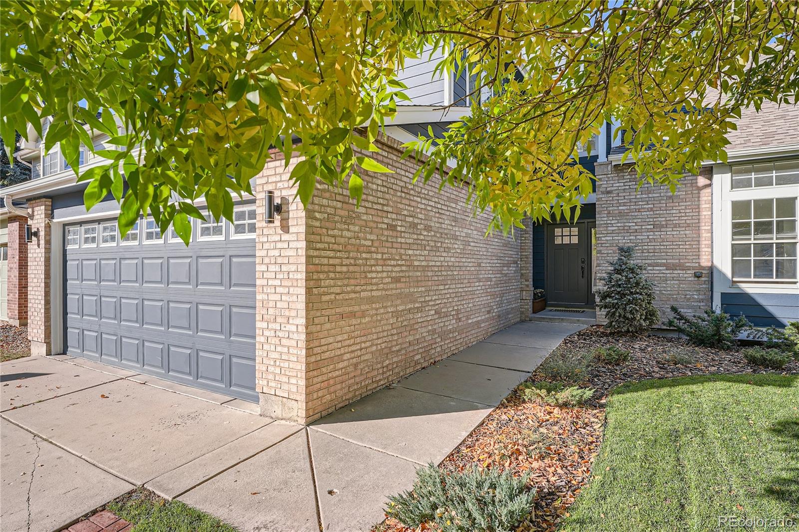 a front view of a house with a tree