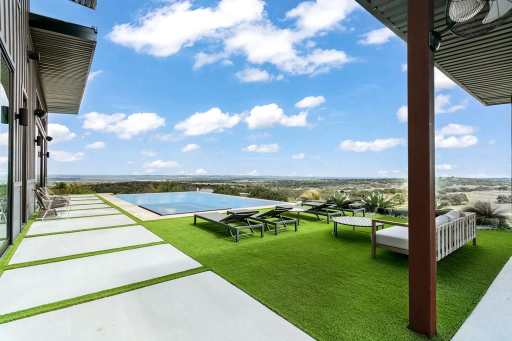 a view of swimming pool with outdoor seating and a garden