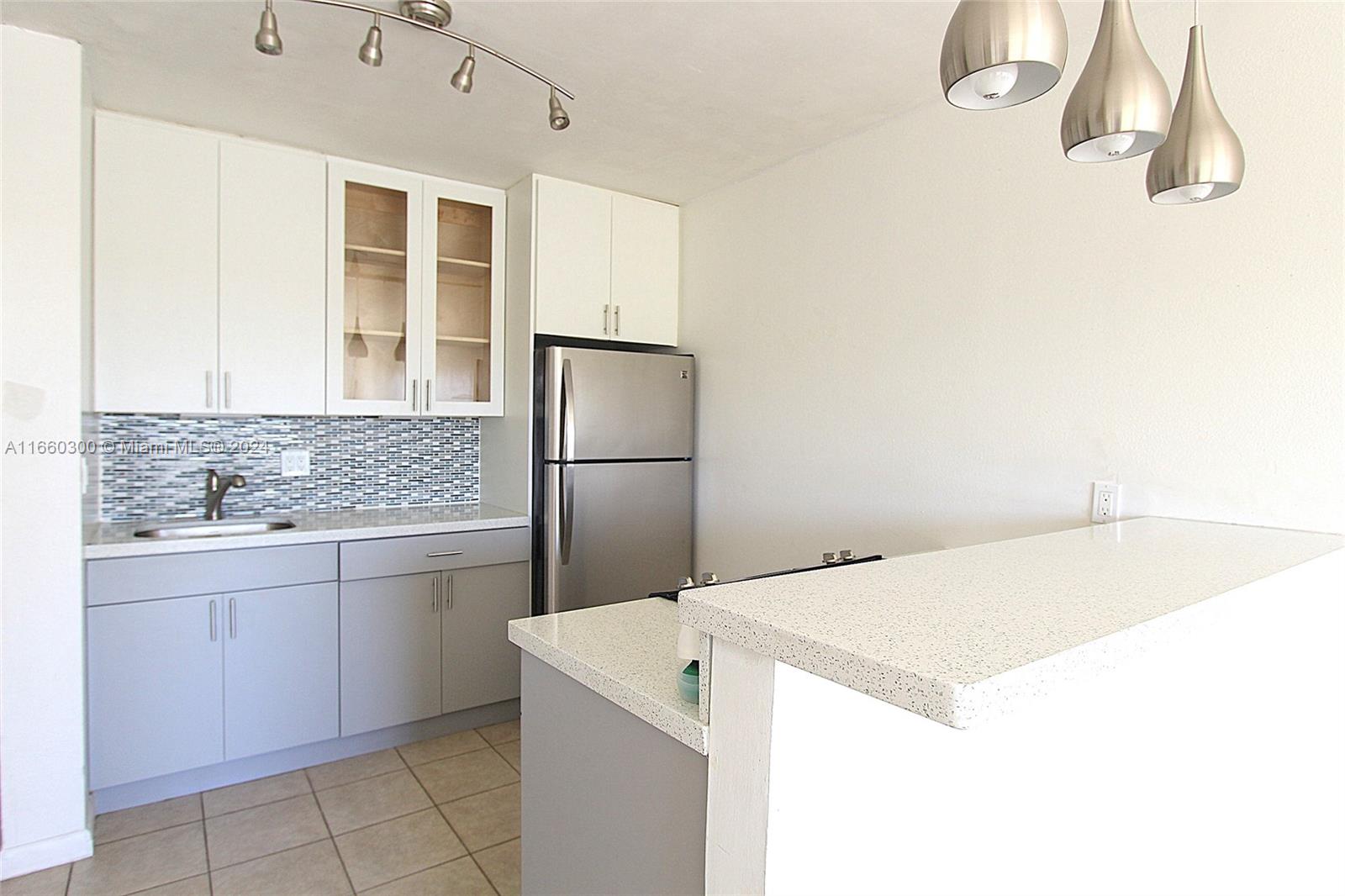 a kitchen with a sink refrigerator and cabinets