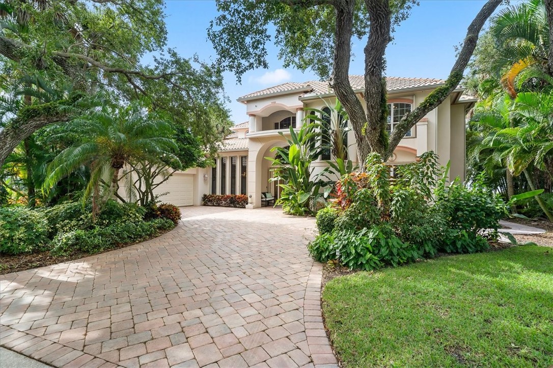 a front view of a house with a yard and trees