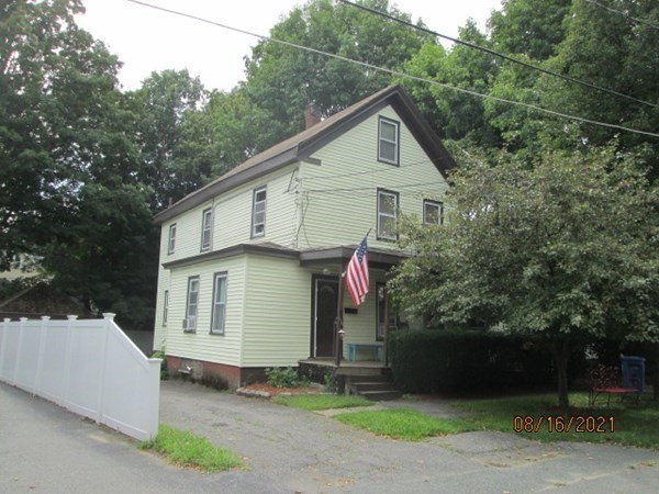 a front view of a house with garage and plants