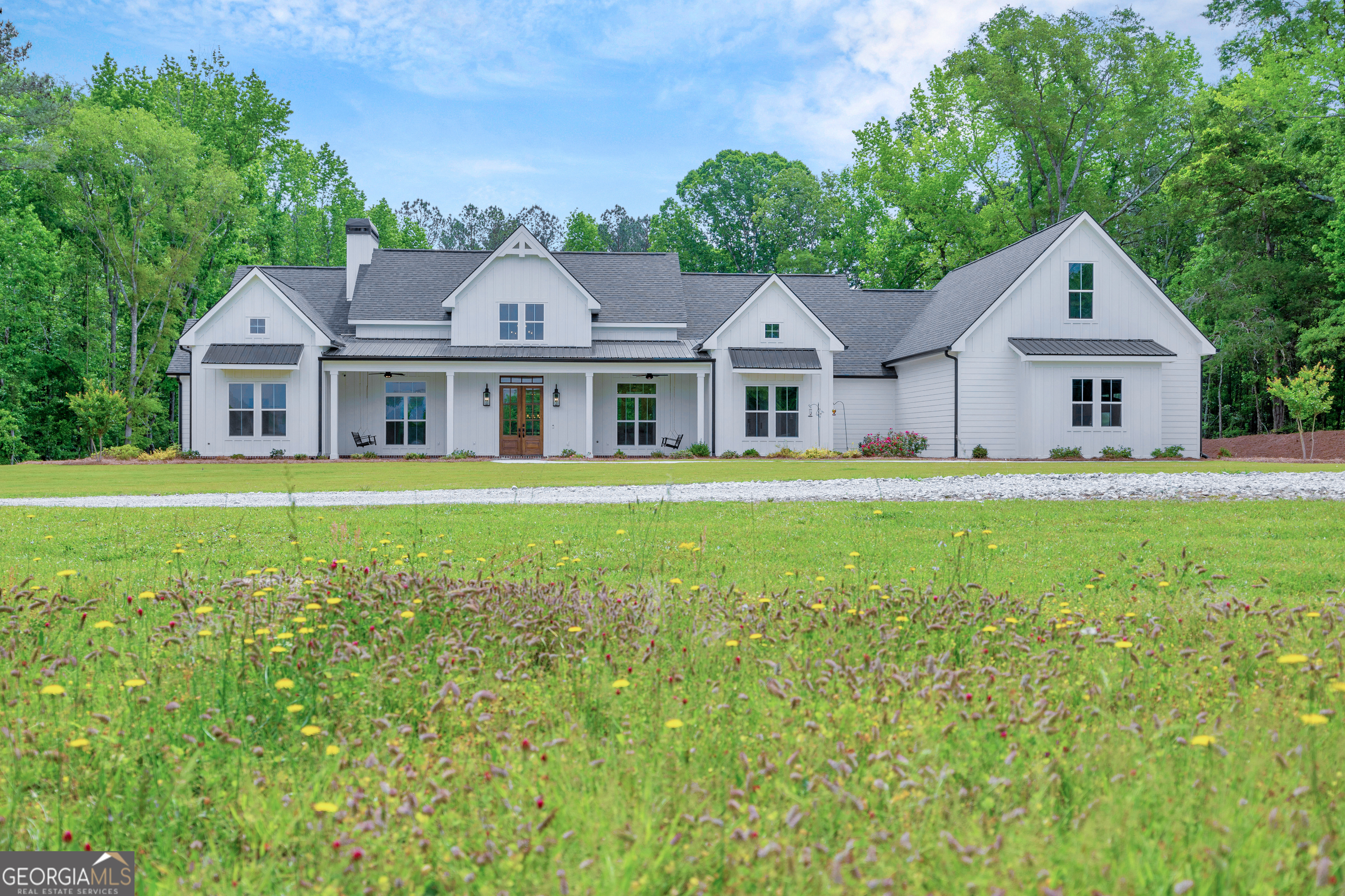 a view of a house with a big yard and large trees