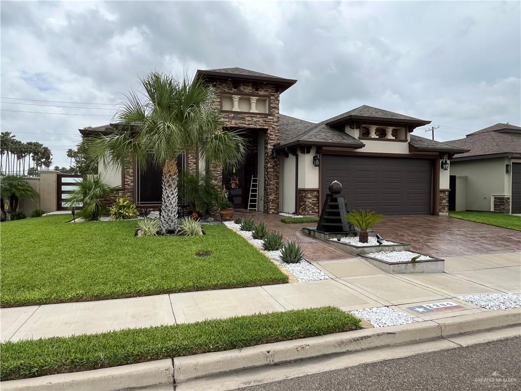 View of front of home featuring a garage and a front lawn