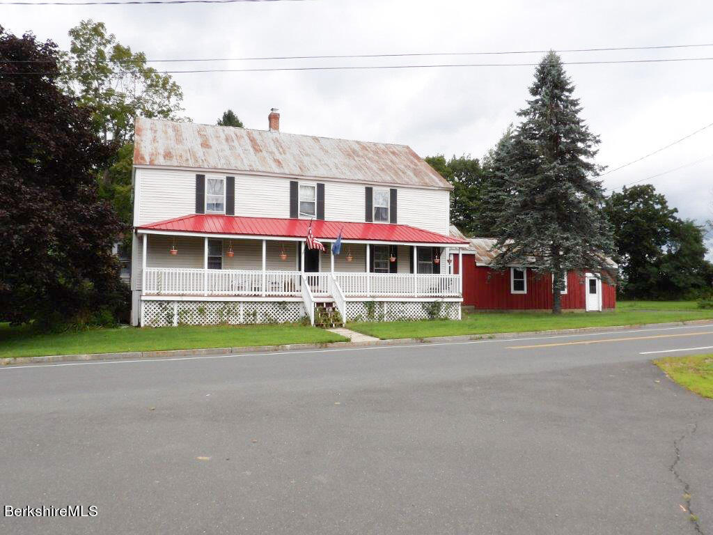 a view of a house with a yard and sitting area