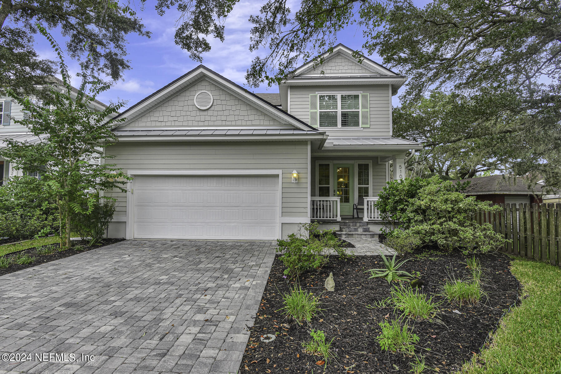 a front view of a house with a yard and trees