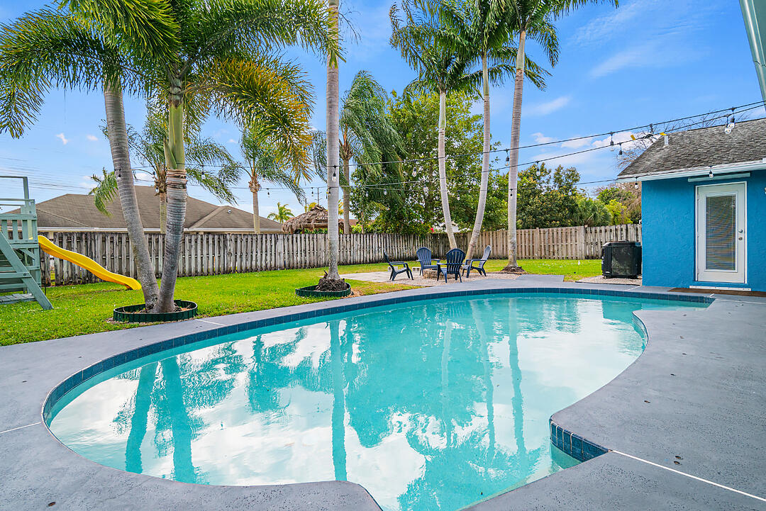 a view of swimming pool with a patio and a garden