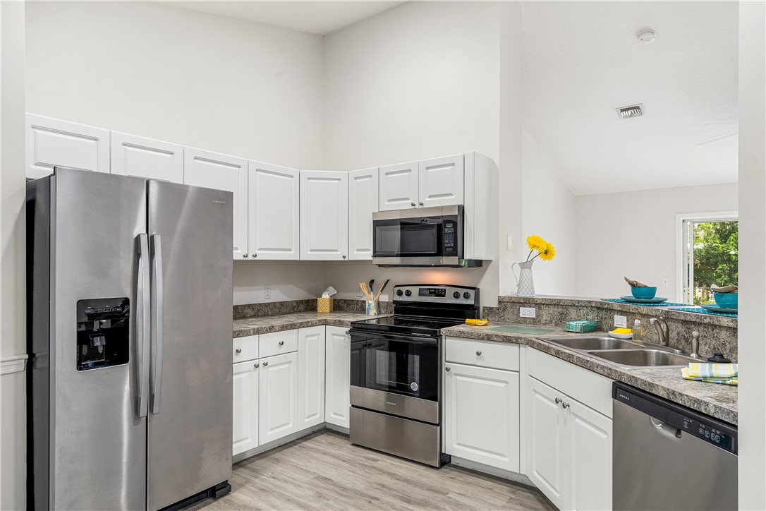 a kitchen with stainless steel appliances a refrigerator stove and sink