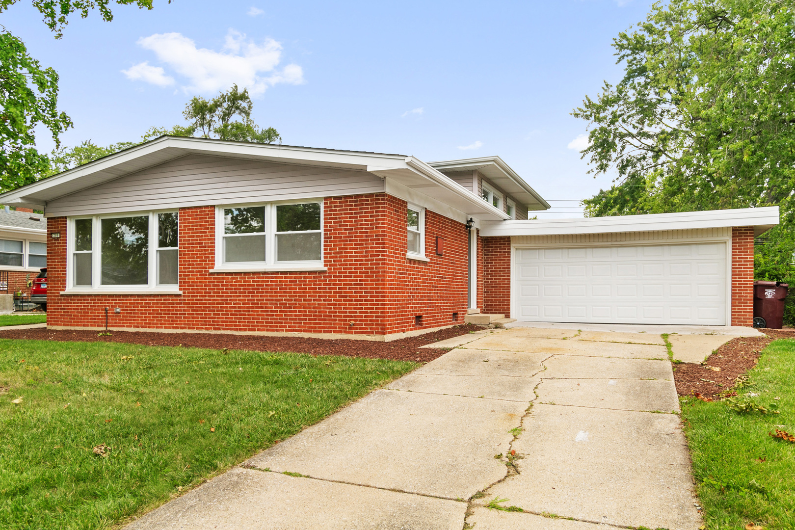 a front view of a house with a garden and yard