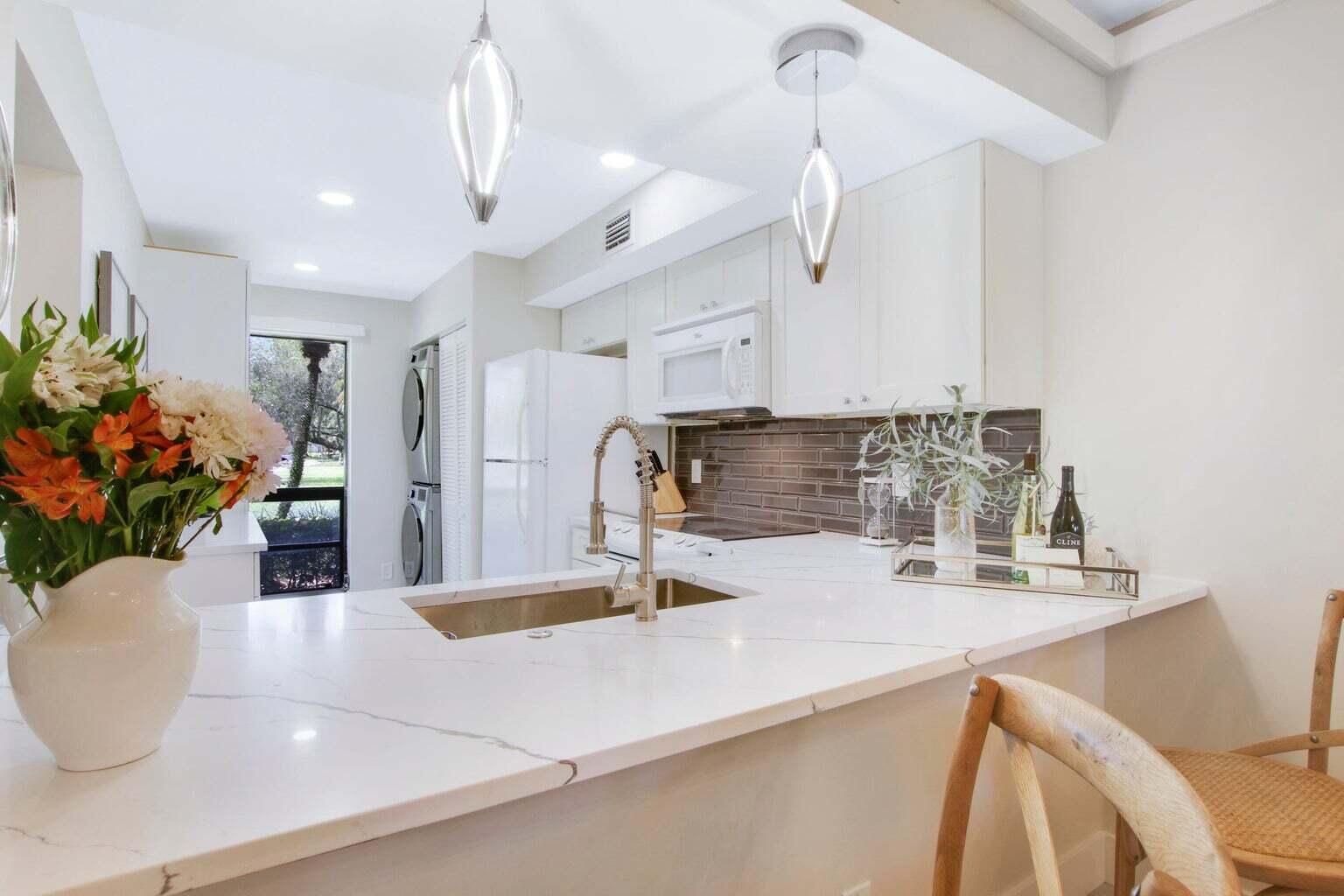 a kitchen with stainless steel appliances granite countertop a sink a stove and a wooden cabinets