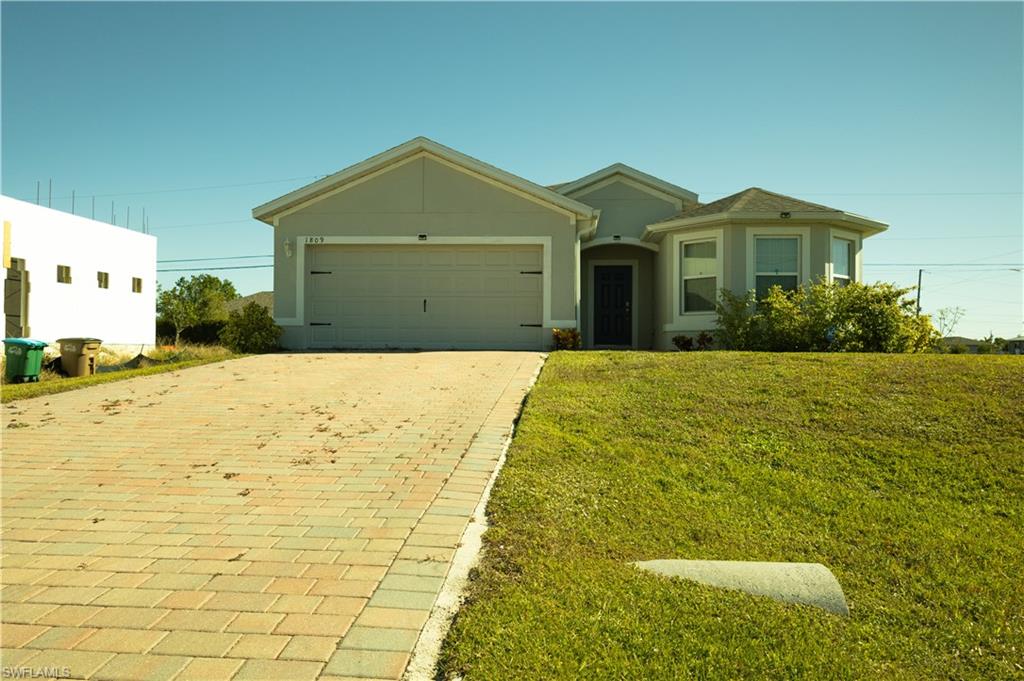 a front view of yellow house with a yard