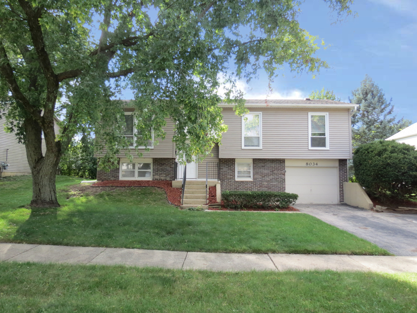 a front view of a house with a garden and yard