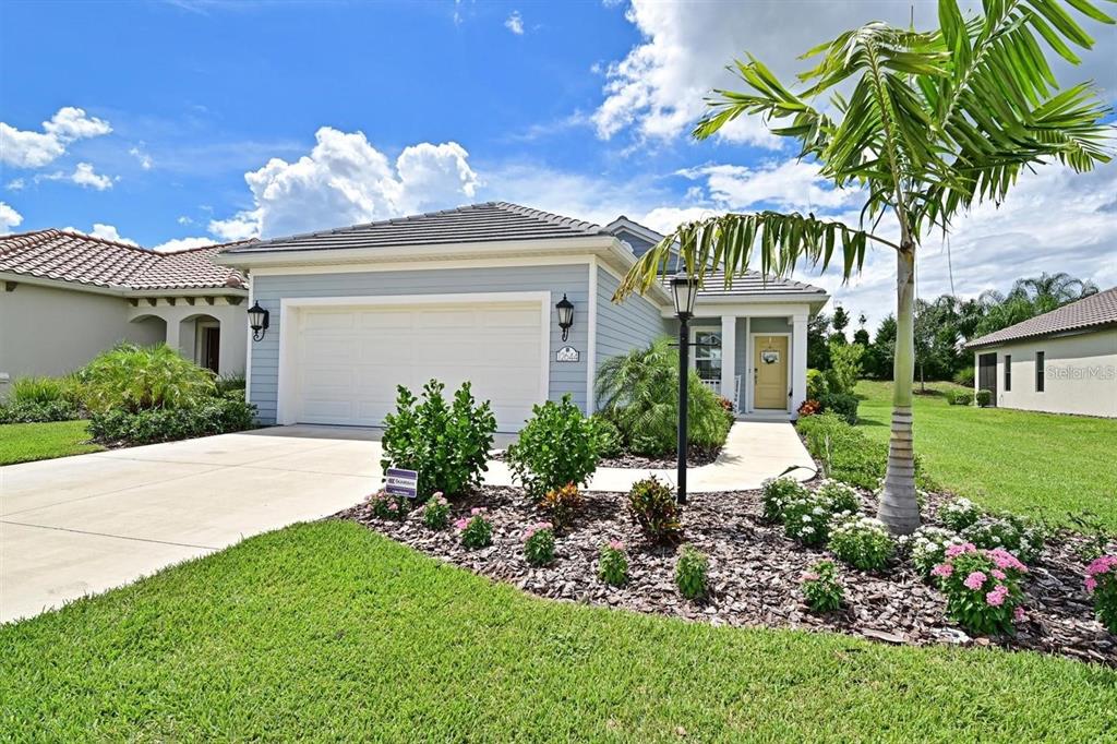 a front view of a house with a yard and potted plants