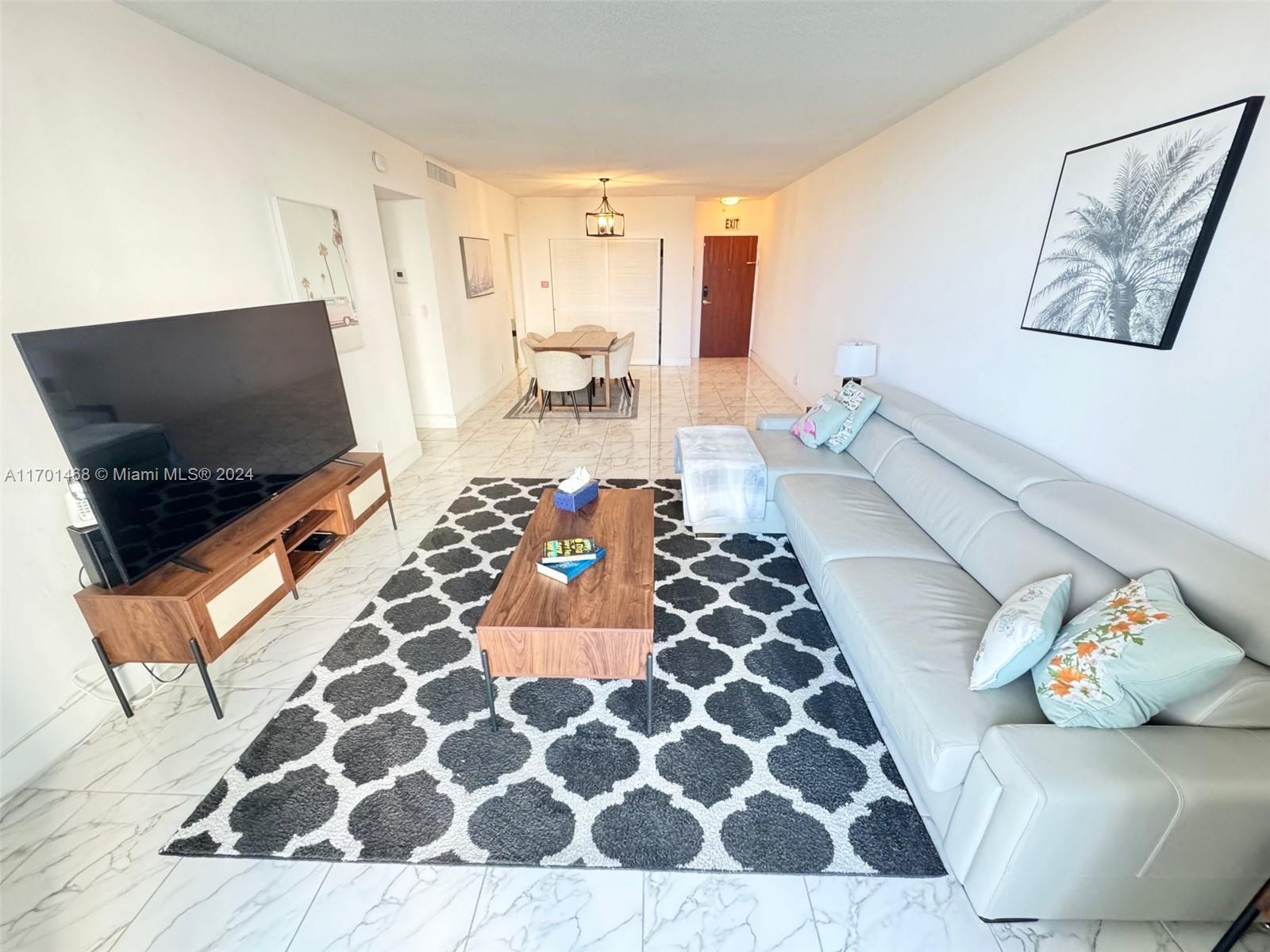 a living room with a rug and a flat screen tv