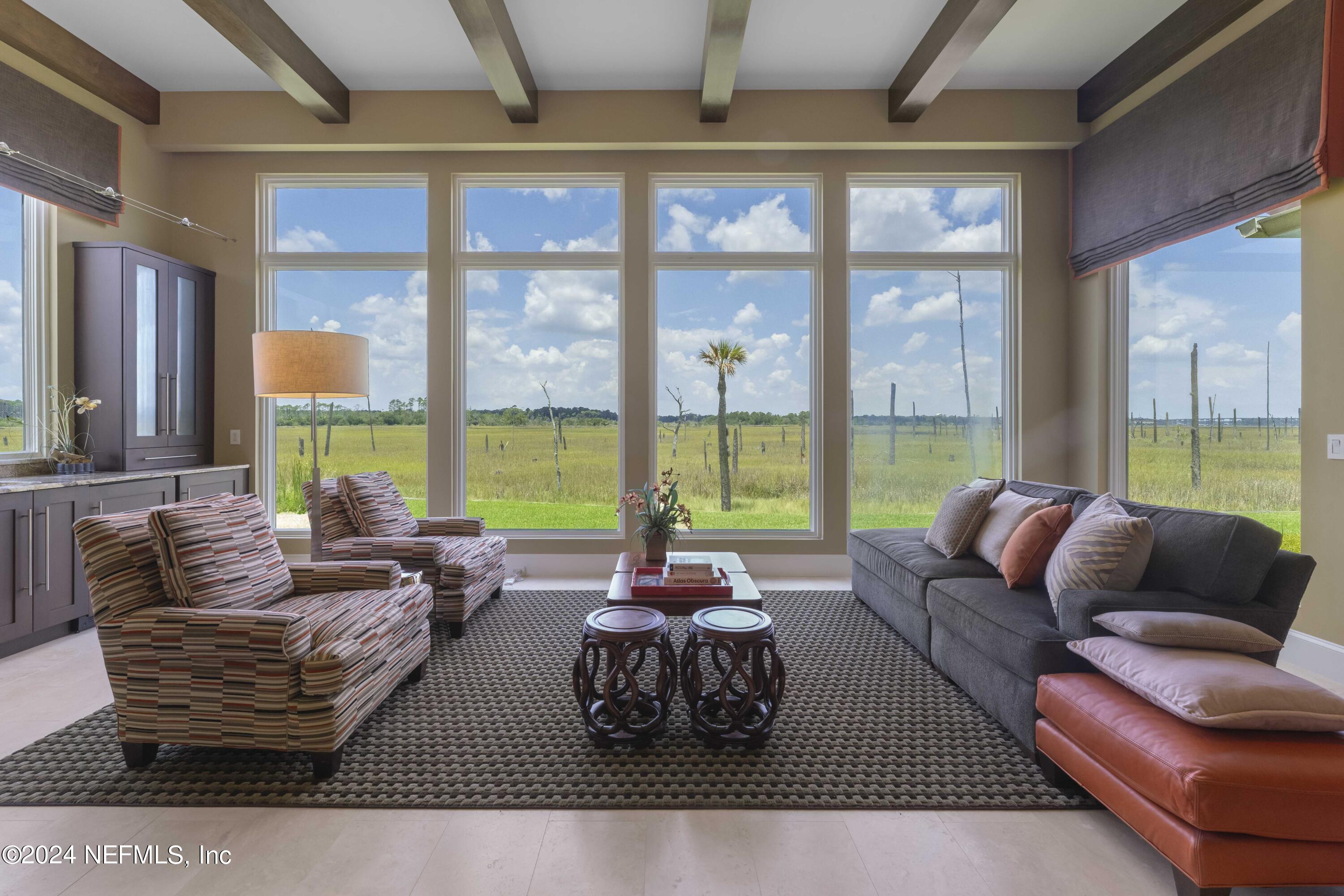 a living room with furniture and large windows