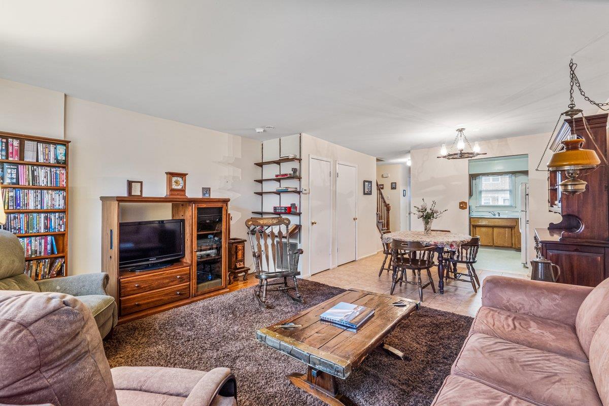 Carpeted living room with a notable chandelier