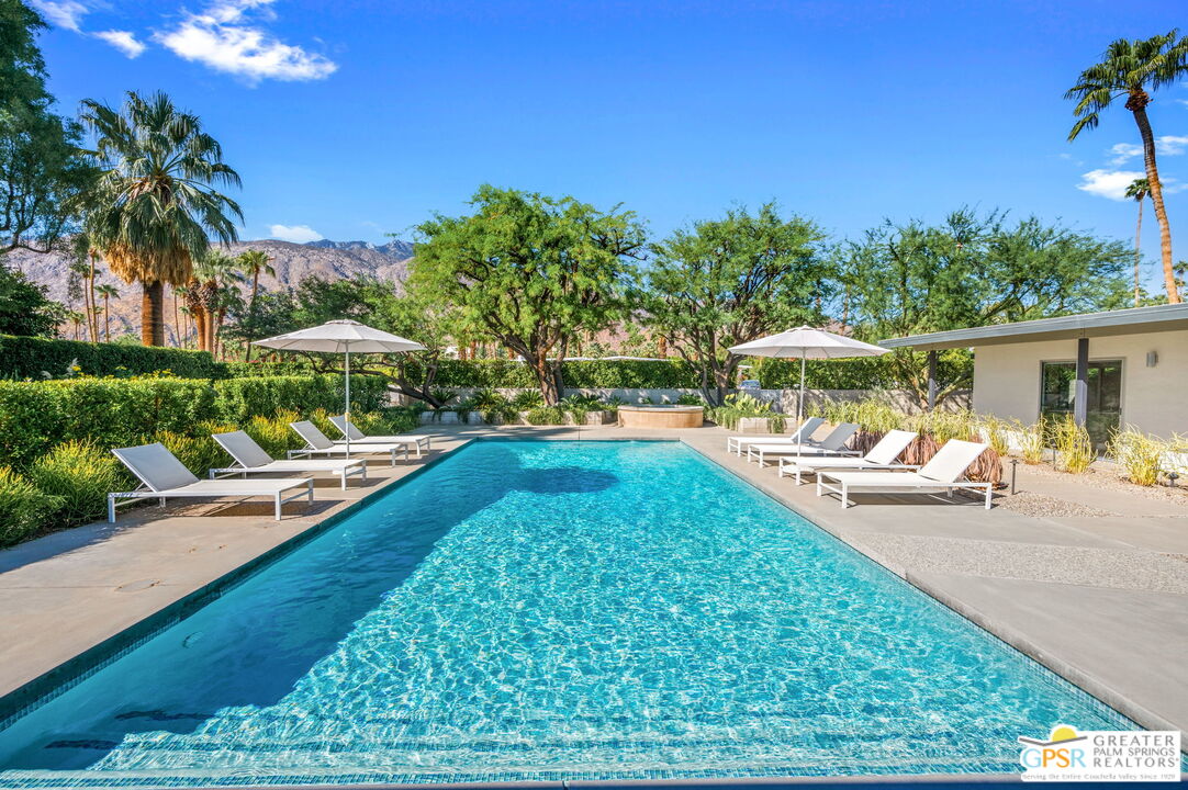 a view of a swimming pool with lounge chairs in patio