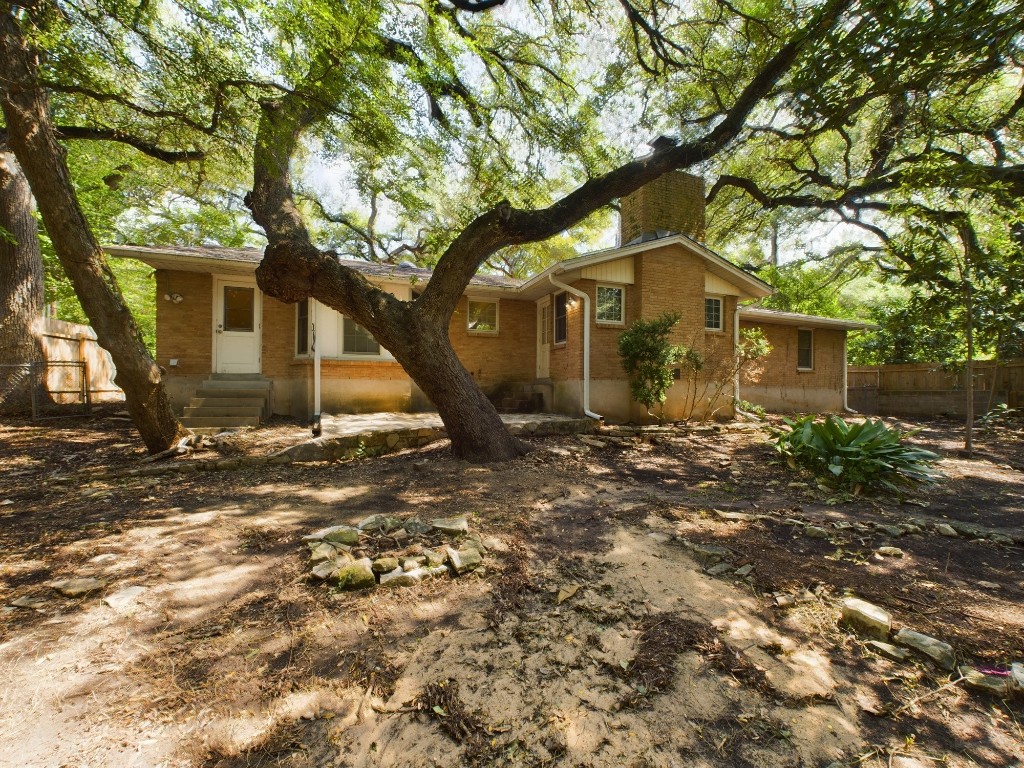 a front view of a house with a tree