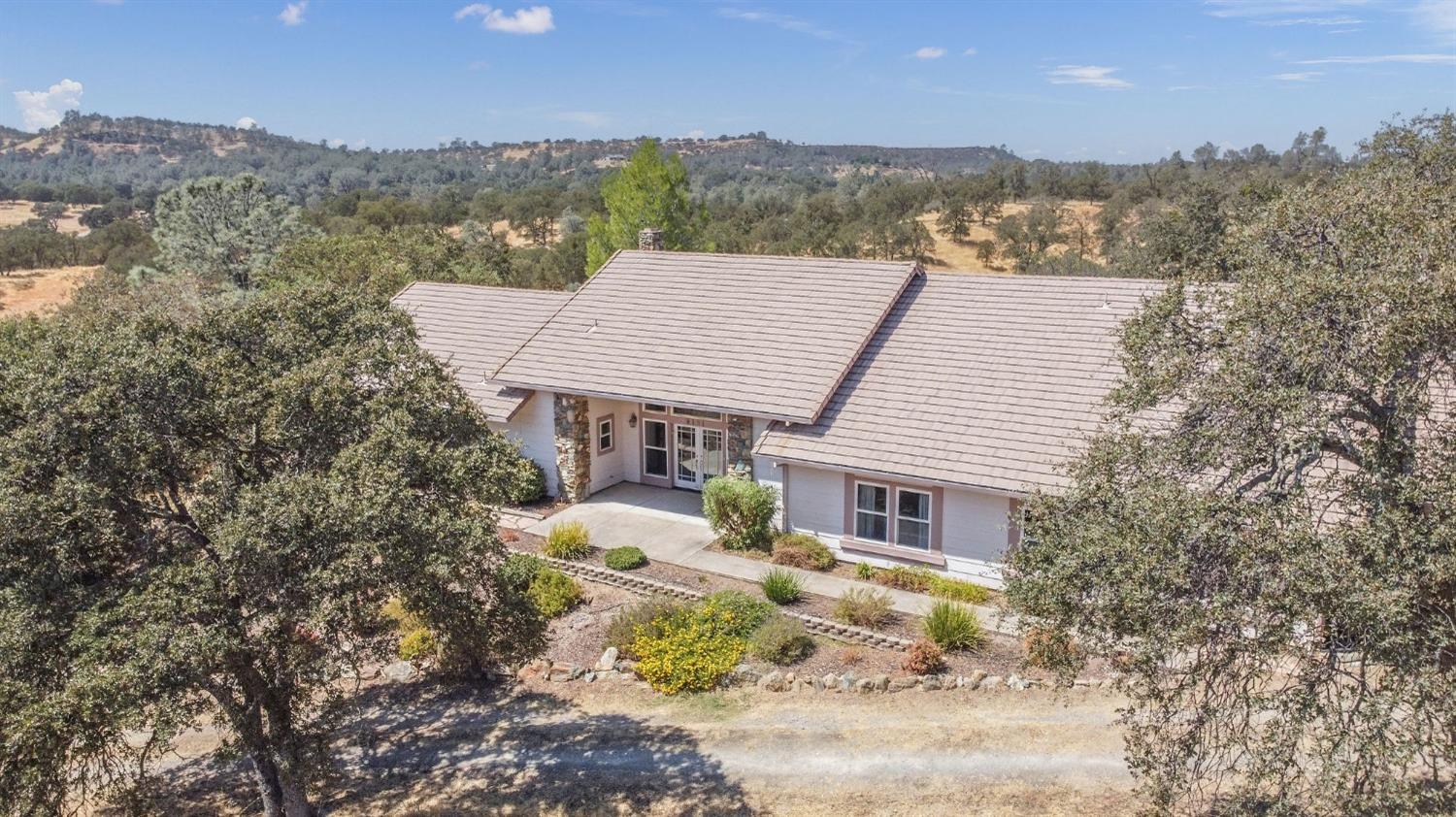 an aerial view of a house with a yard and mountain view in back