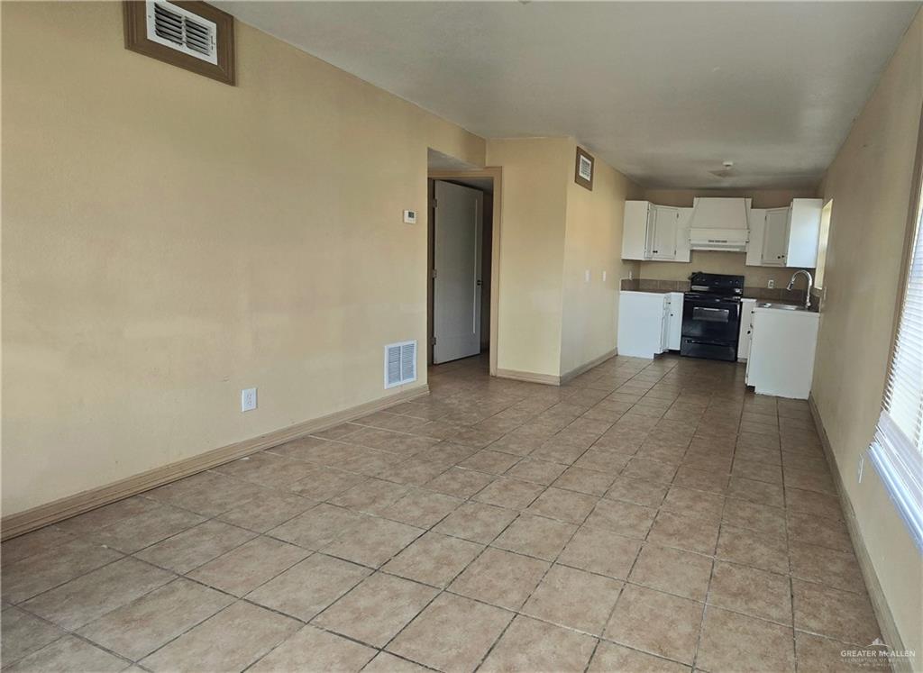 Unfurnished living room with light tile patterned floors and sink