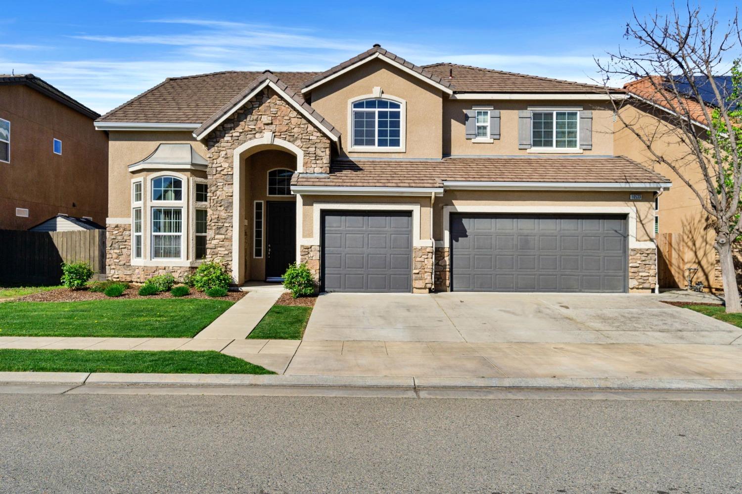 a front view of a house with a yard and garage