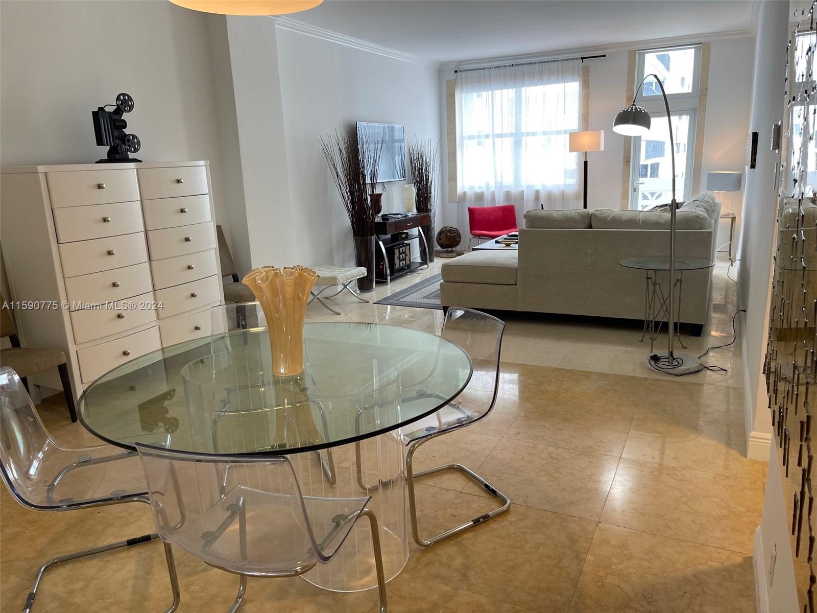 a living room with table chairs and a flat screen tv