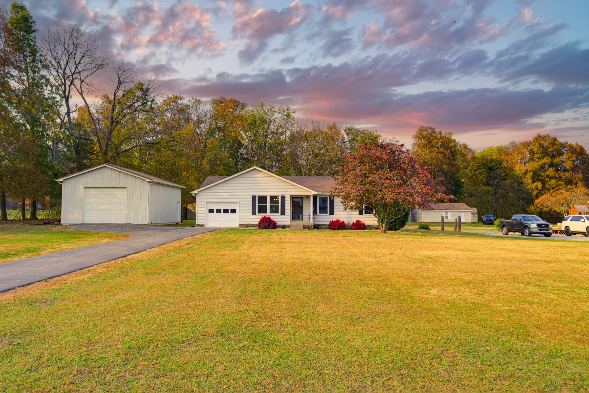 a front view of house with outdoor space and trees in the background