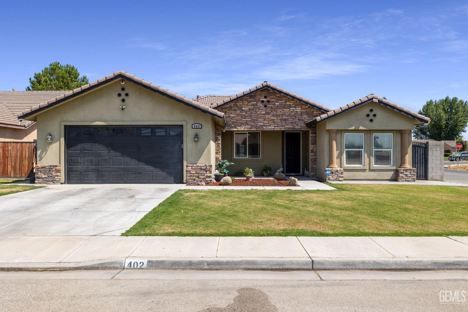 a view of a house with a yard potted plants and a garage