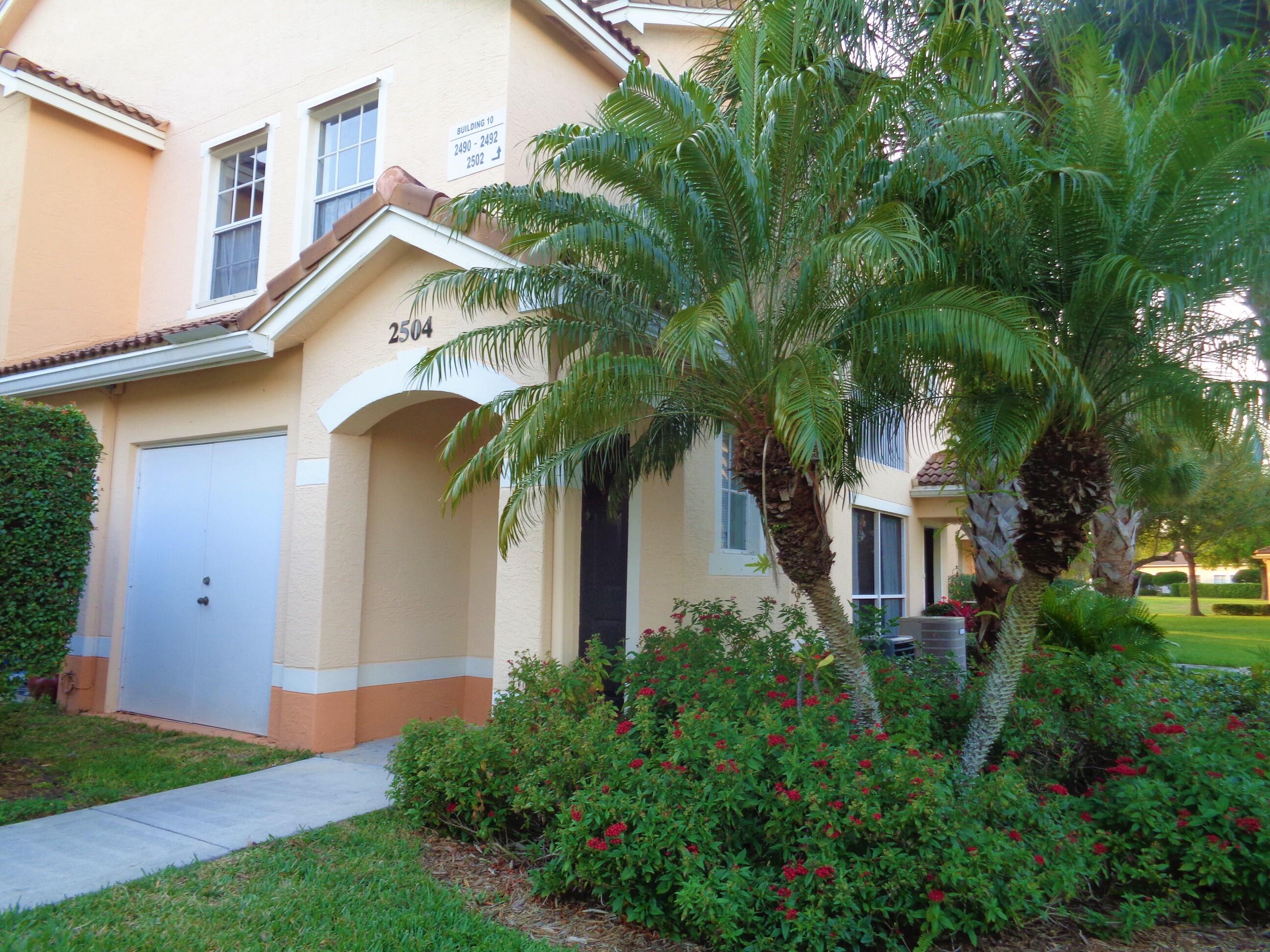 a view of house with garden and tall trees