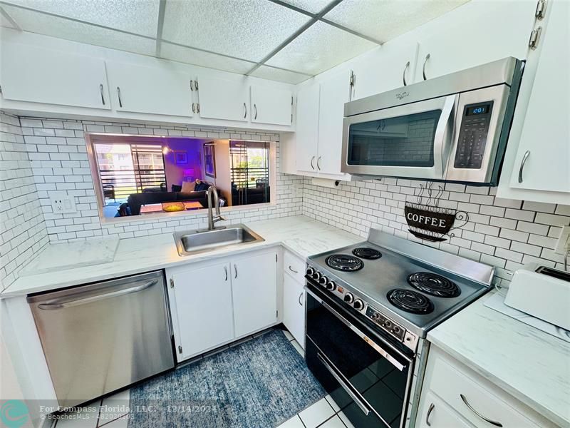 a kitchen with stainless steel appliances a stove a microwave sink and cabinets