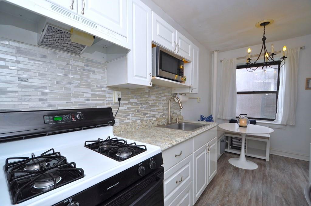 a kitchen with stainless steel appliances a stove a sink a microwave and cabinets