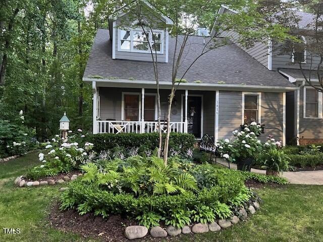 a view of a house with potted plants and a large tree