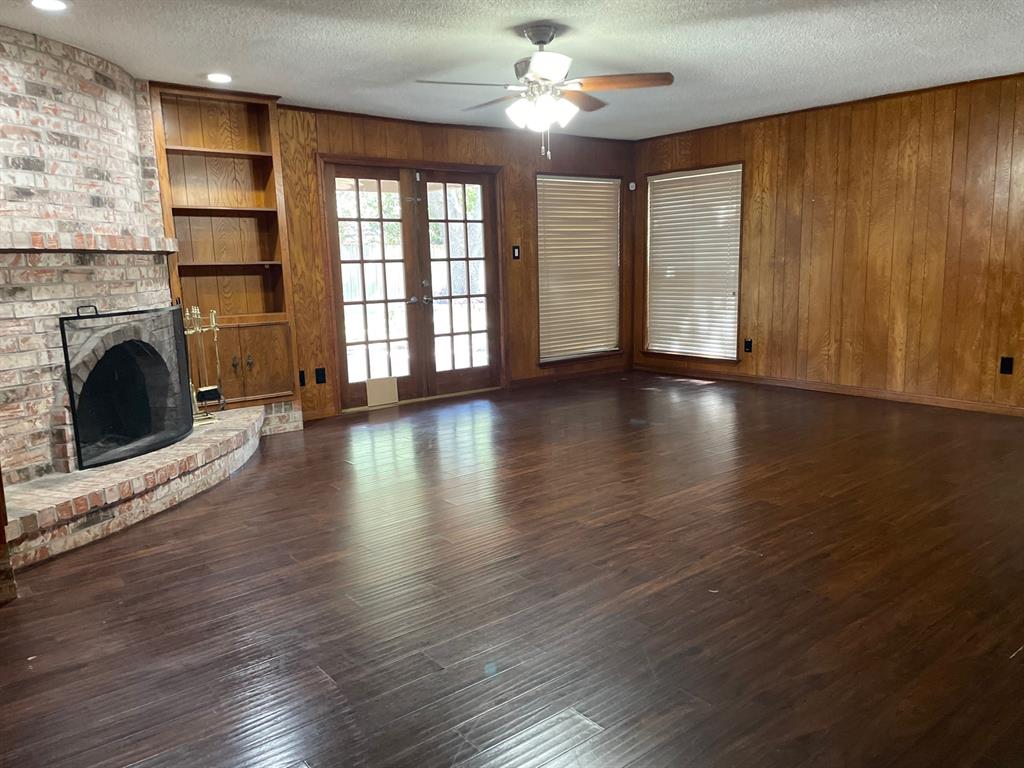 wooden floor fireplace and windows in an empty room