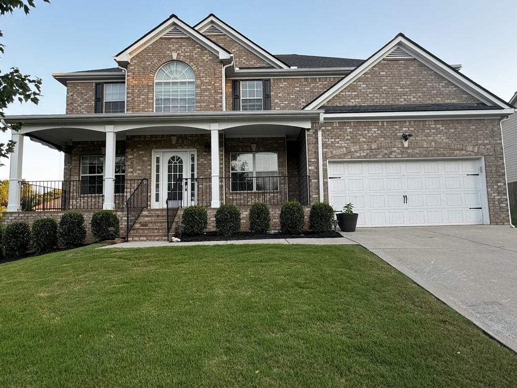 a front view of a house with a garden and yard