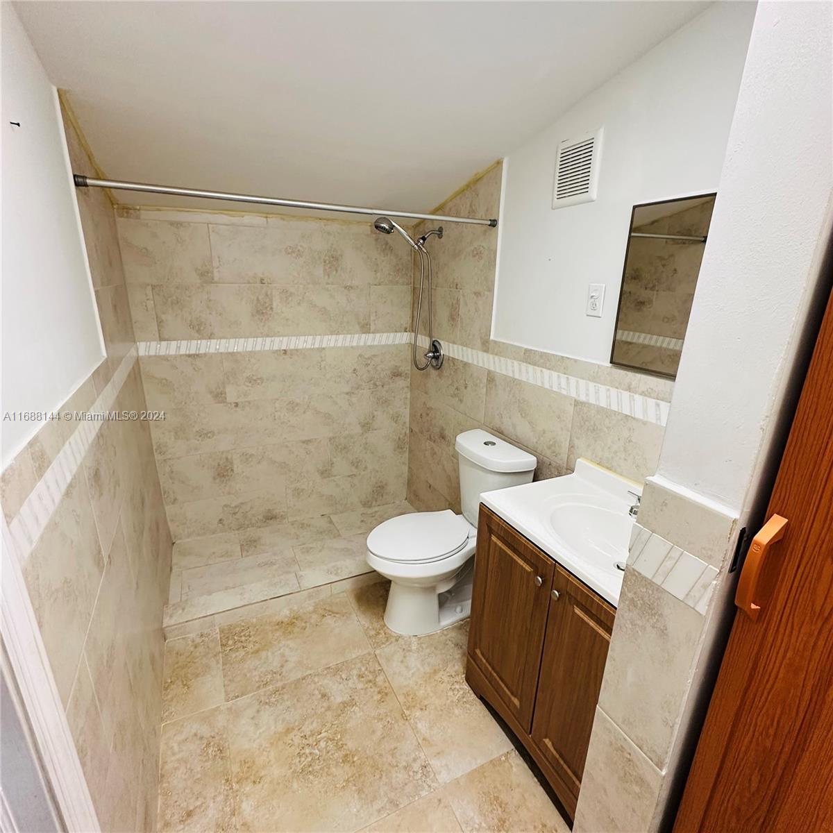 a bathroom with a granite countertop sink a toilet and a shower