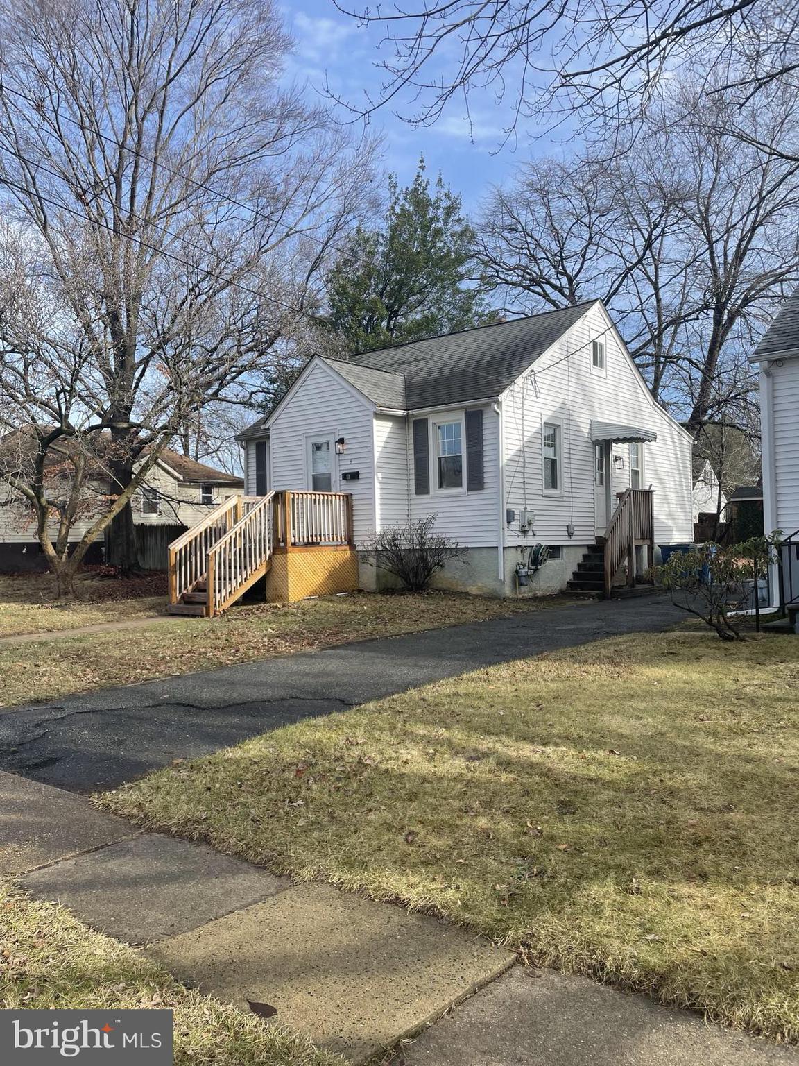 a front view of a house with a yard covered with snow and cars