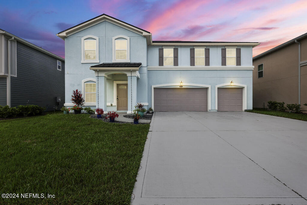 a front view of a house with a yard and garage