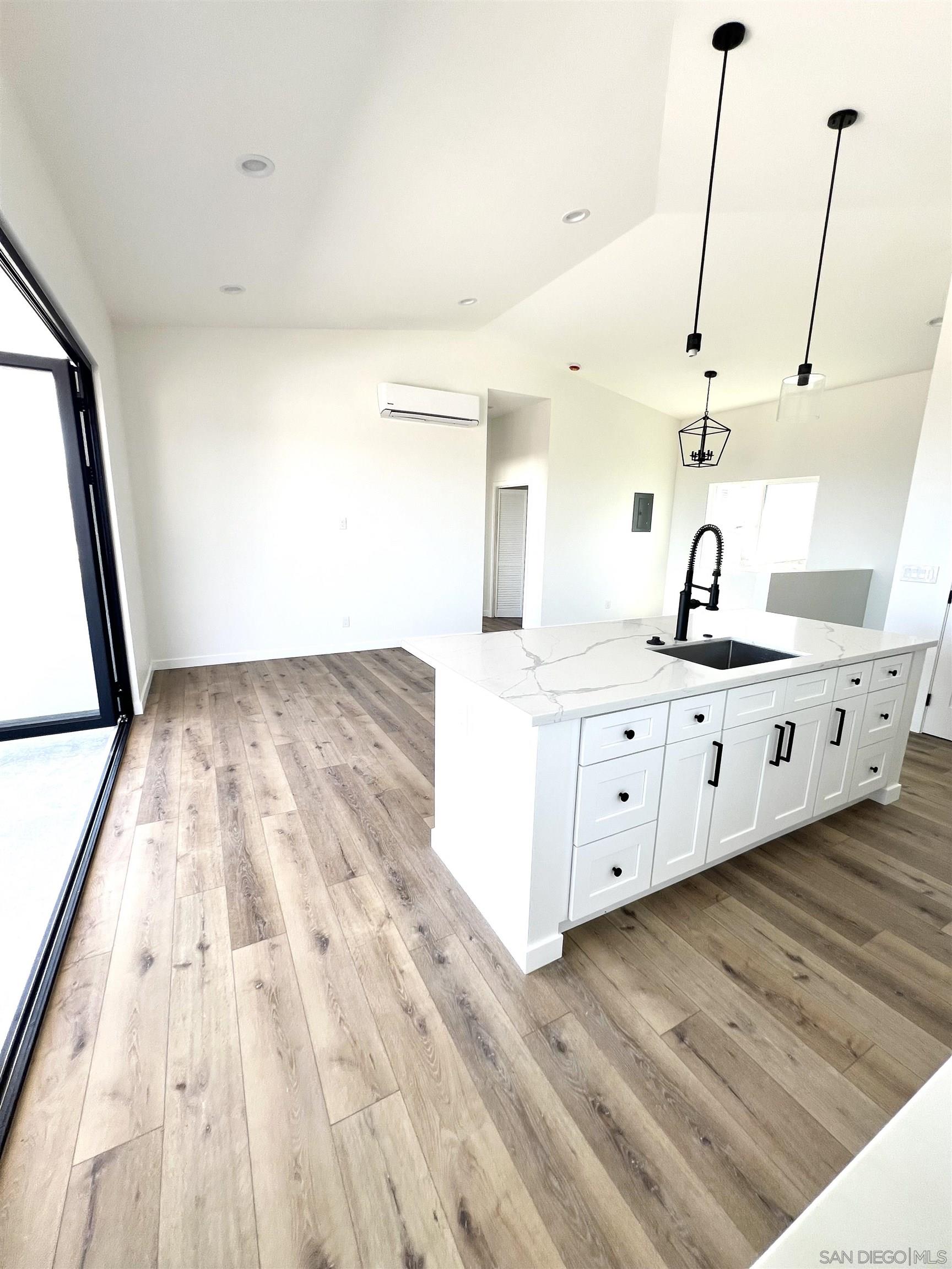 a kitchen with kitchen island sink and wooden floor