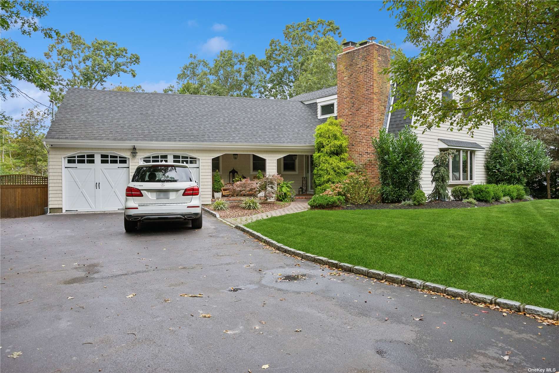 a white house in front of a yard with potted plants