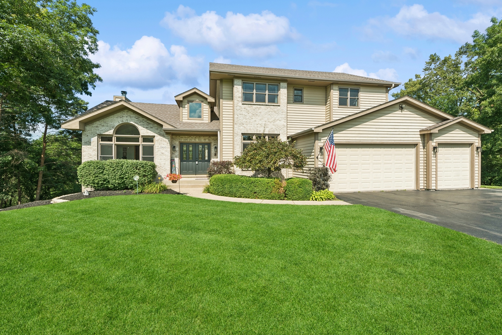 a front view of a house with a garden and plants