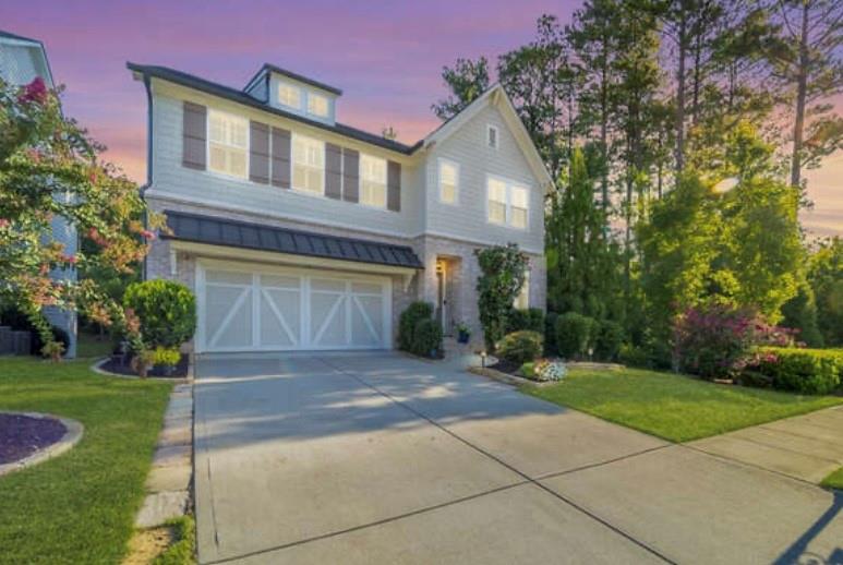 a front view of a house with a yard and trees