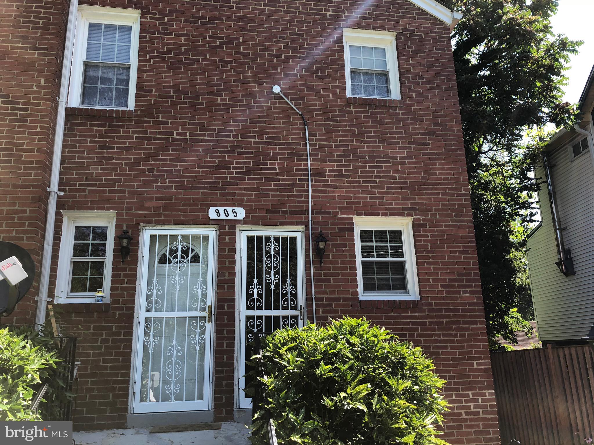 a view of brick house with potted plants