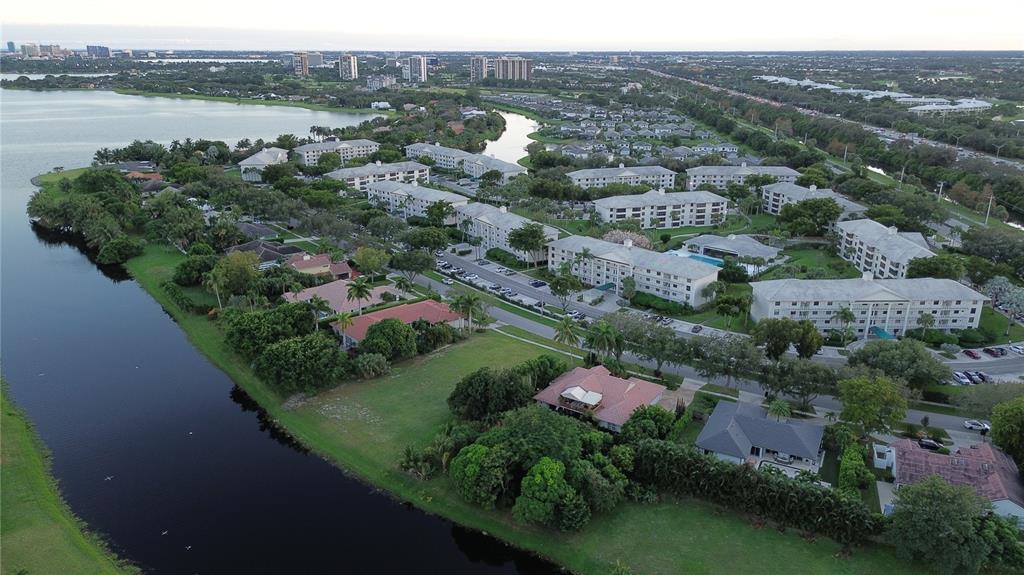 an aerial view of lake and residential houses with outdoor space and swimming pool