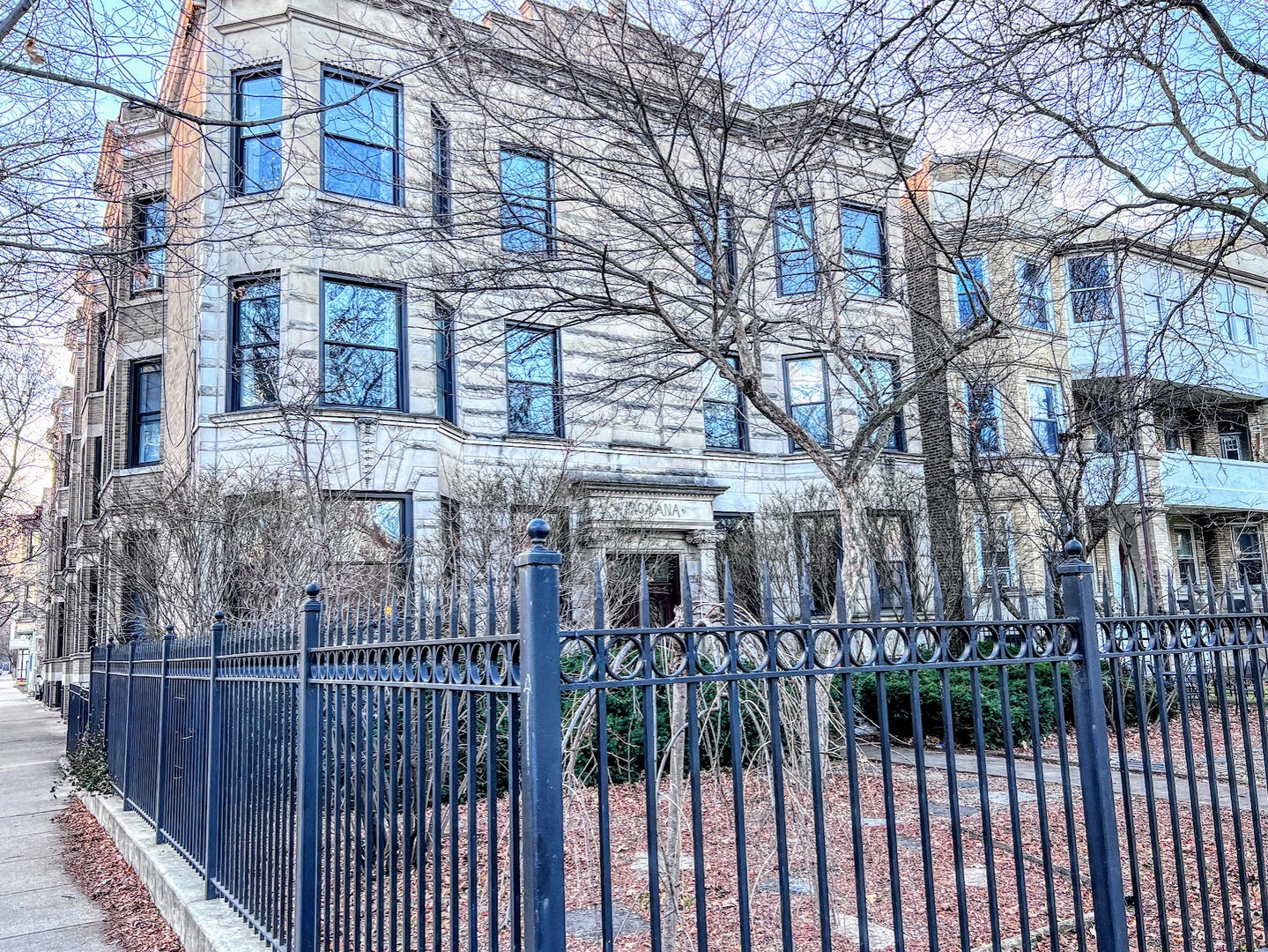 a view of a brick house with iron fence