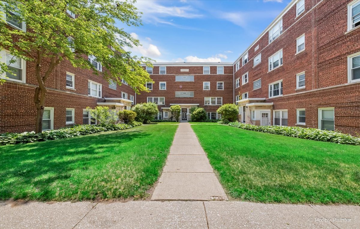 a view of a brick building next to a big yard