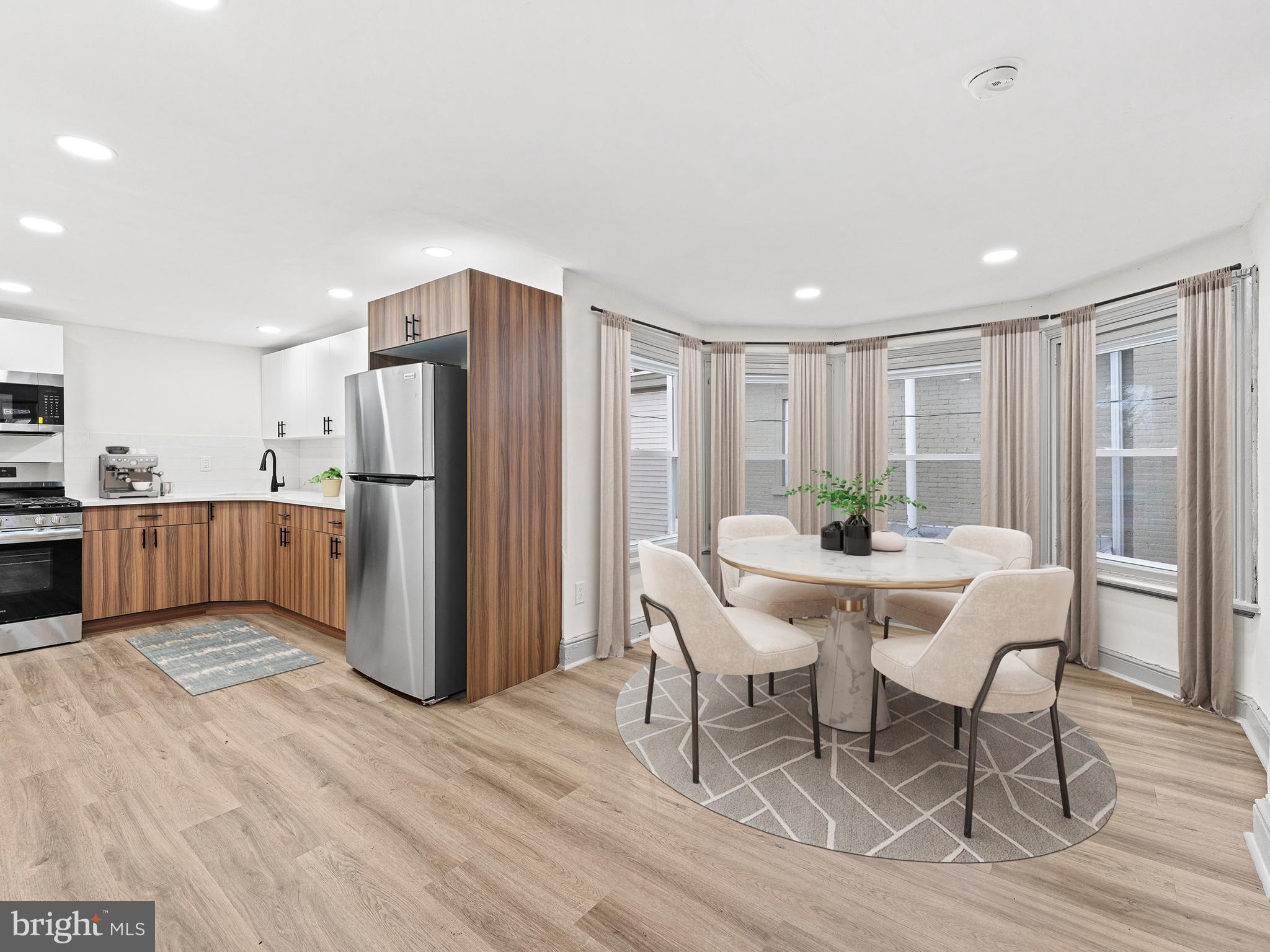 a view of kitchen with refrigerator and wooden floor