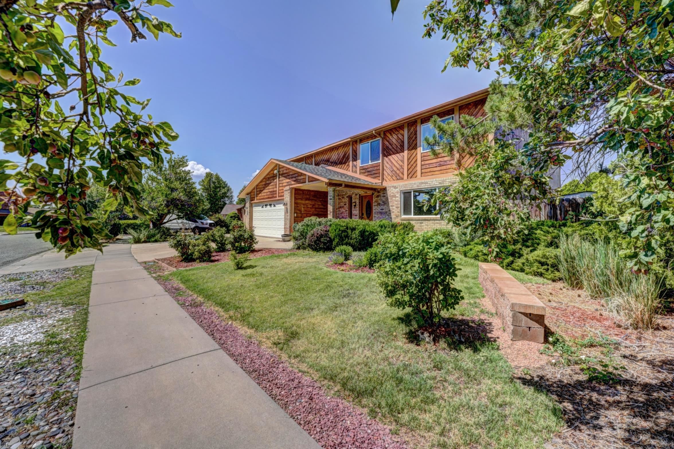 a front view of a house with a yard and trees